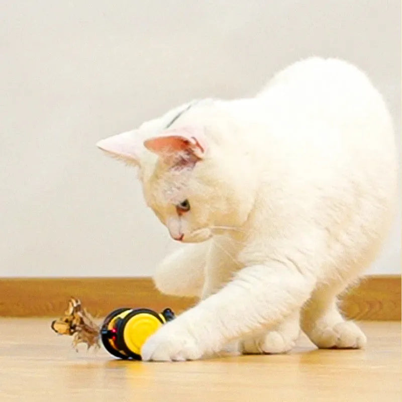 Electric cat car toy in pink with feather teaser stick, moving randomly on a carpet