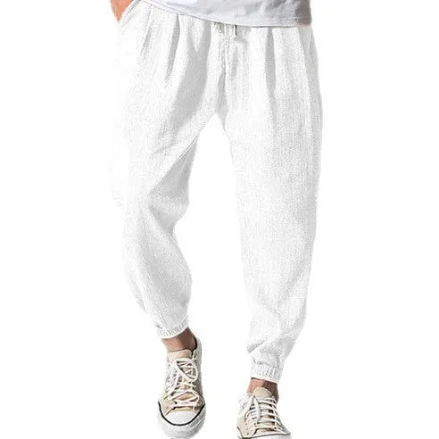 Men's loose cotton ankle banded trousers in khaki colour on a hanger.