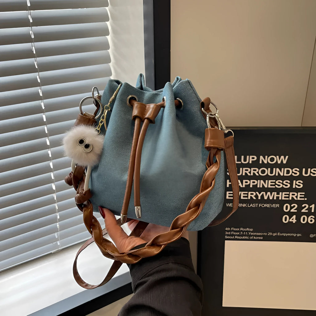 Blue synthetic leather cross body bucket bag with one-shoulder strap and outer pocket