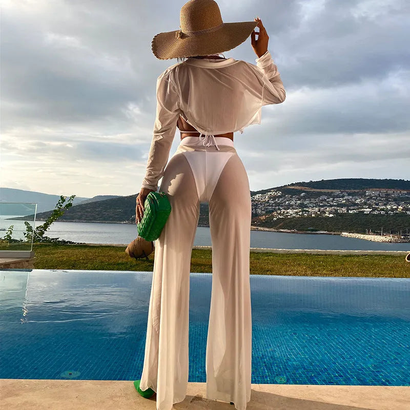 Women's white four-piece swimsuit set with high waist bottoms and backless top on a beach background