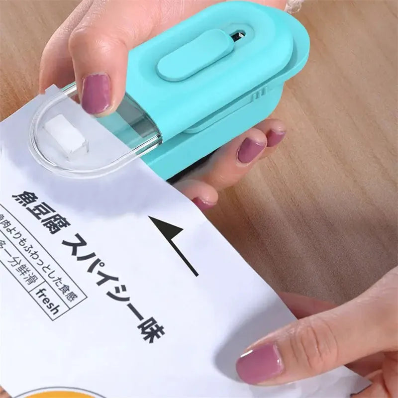 Multi-functional handheld portable battery-powered food bag sealer with sealing and cutting heads, black colour, on white background
