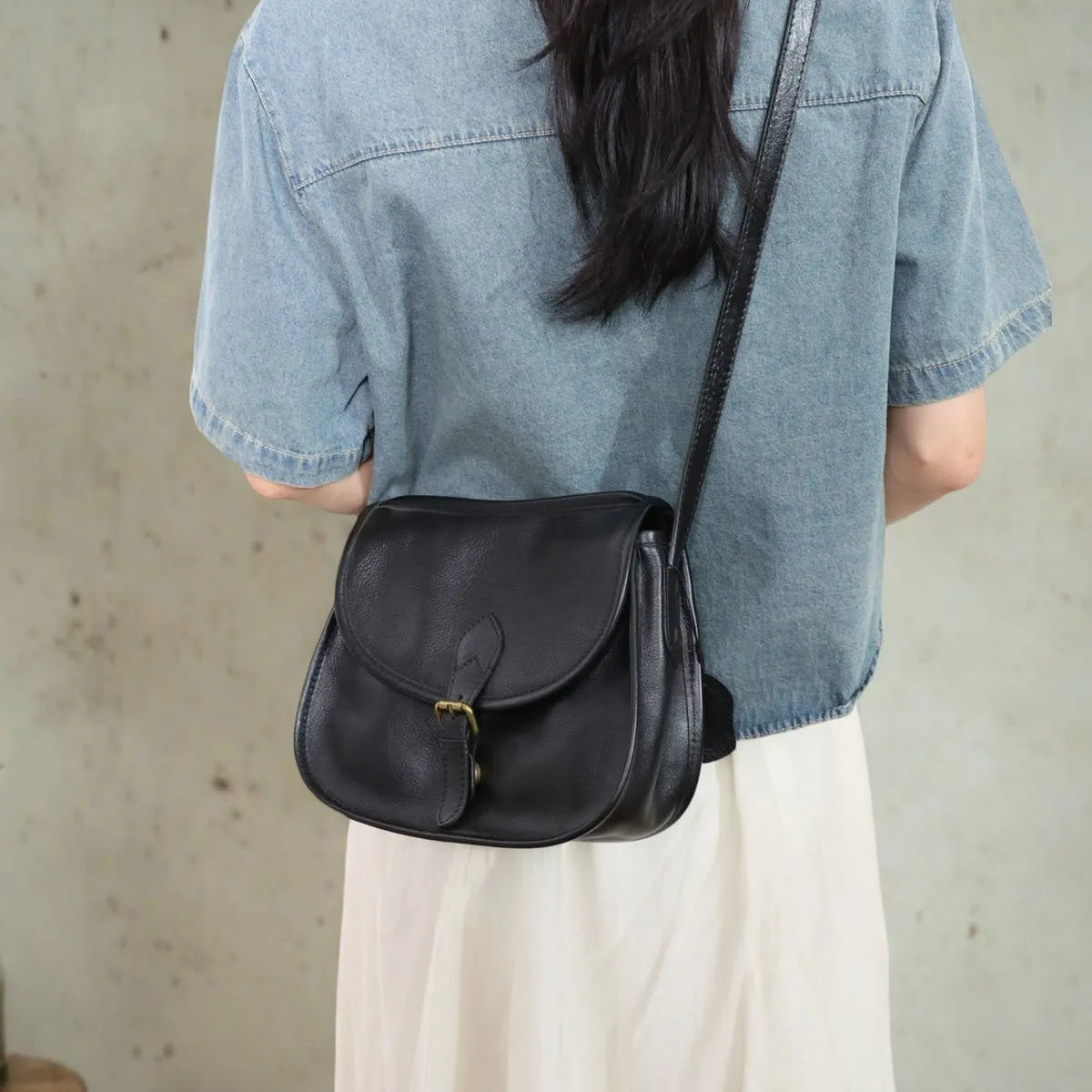 Genuine leather messenger bag with shell shape and sewing line detail in brown