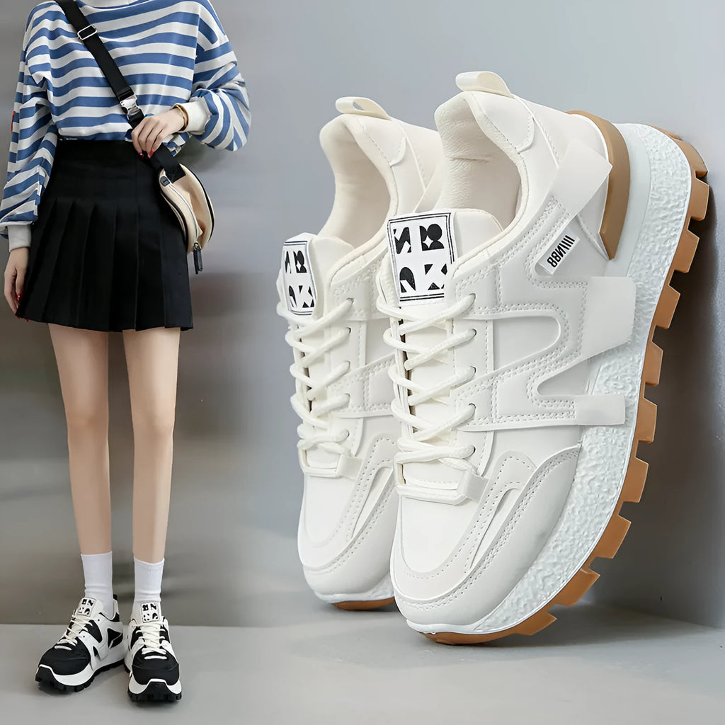 Low-top white and black casual sneakers with round toe and lace-up closure on a plain background.