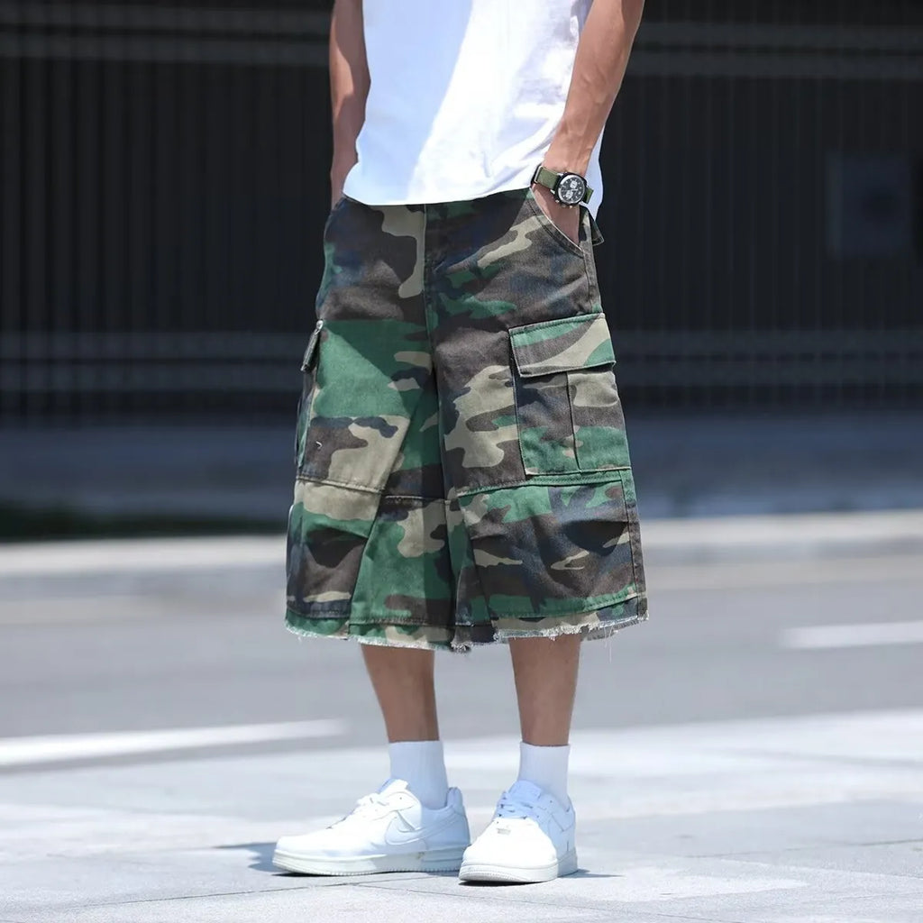 Man wearing loose-fit cropped camouflage shorts in retro American workwear style.