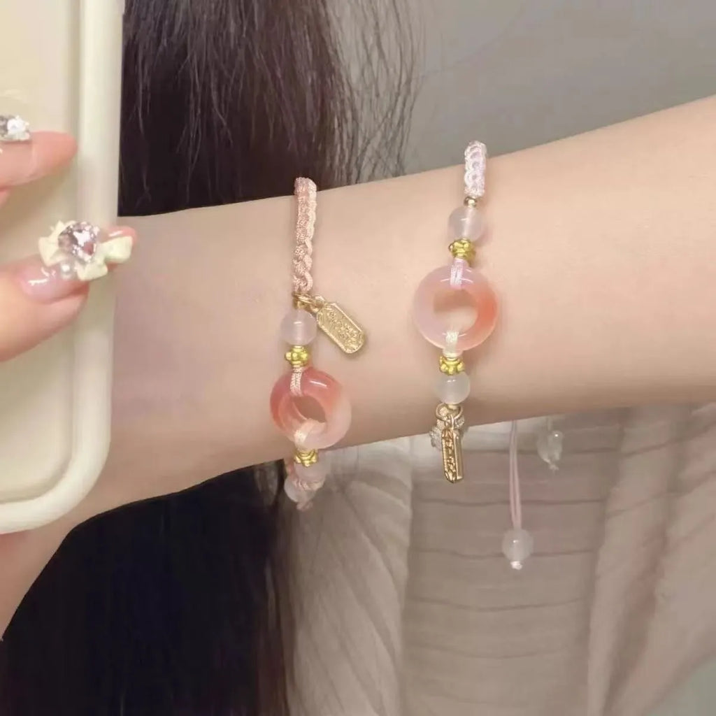 DIY woven watch band with peace buckle in peach blossom green, pink, and black colours on a unisex hand strap