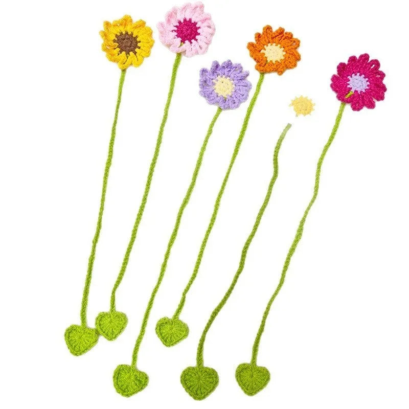 Hand-crocheted daisy wool bookmark with flexible wire on open book