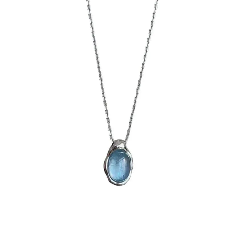 Navy blue water droplet necklace with geometric cross chain on white background