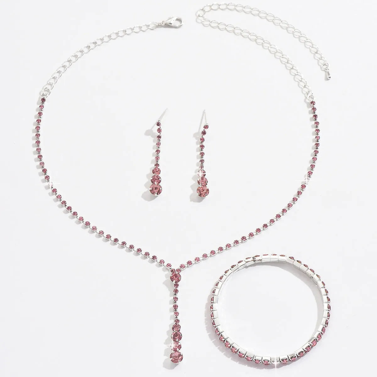 Rhinestone bridal jewellery set includes necklace, bracelet, and earrings in silver with tassel and heart elements