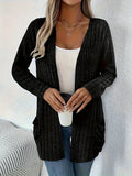 Man wearing a solid grey loose-fit long sleeve cardigan with side pockets.