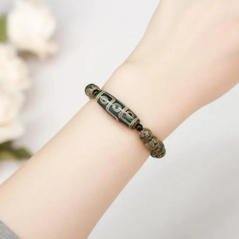 Handmade green dzi bead barrel shaped bracelet with 8mm natural agate beads on white background