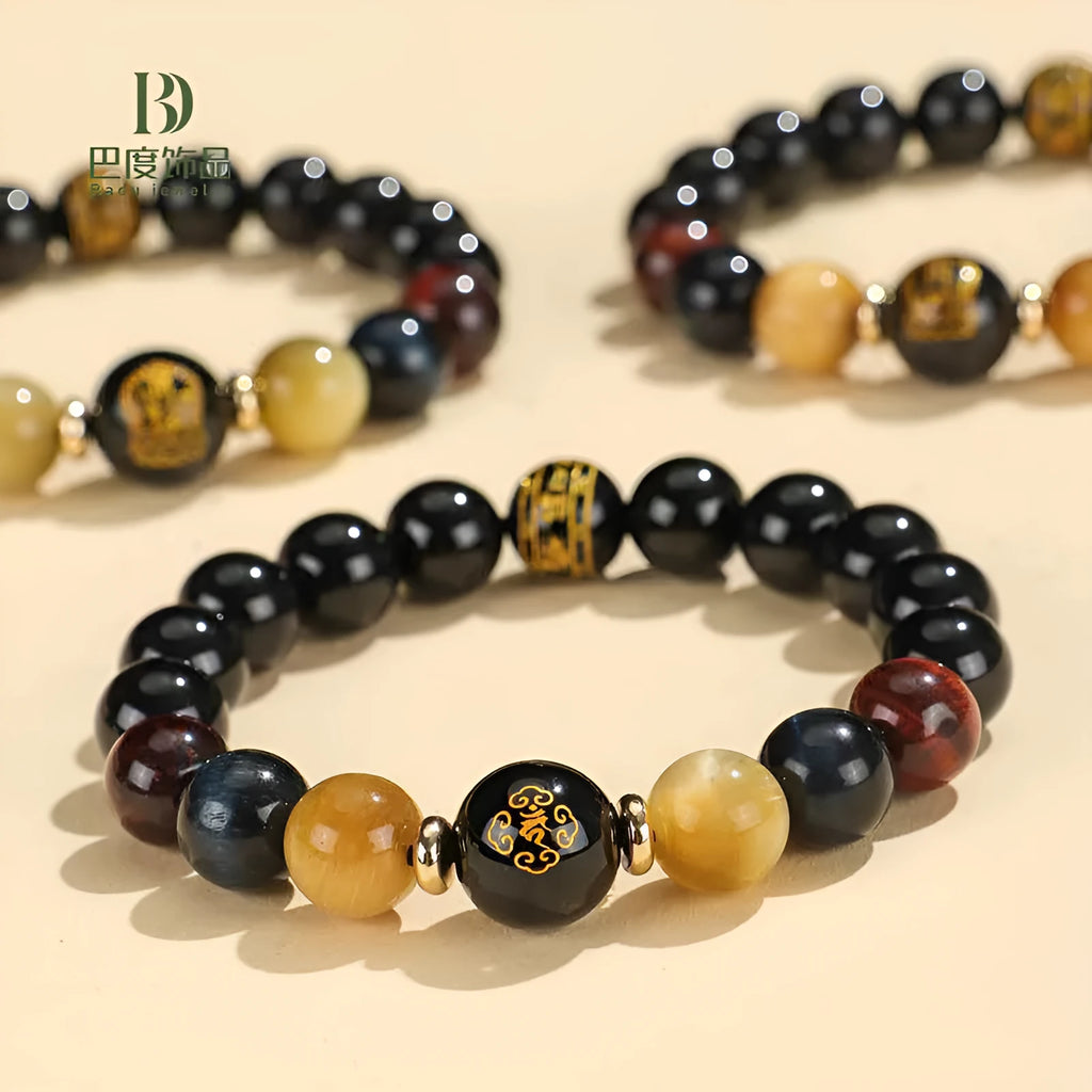 Black agate beaded bracelet with gold tiger eye accent and Chinese zodiac bodhisattva charm on neutral background