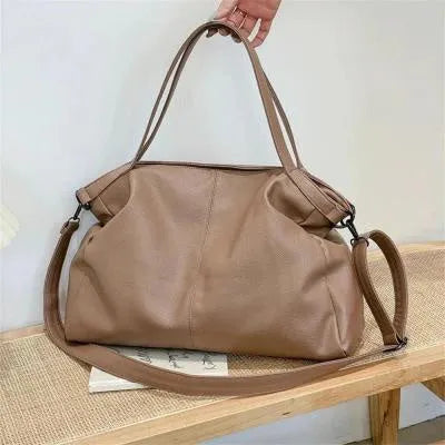 Large soft surface PU messenger bag in horizontal square shape with shoulder strap and top handle.