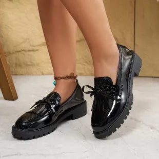 Women's brown loafers with a decorative bow on the front.