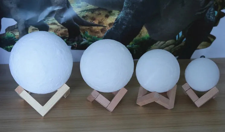 Luna Tranquil Moon Lamp with realistic moon texture and touch colour control on a bedside table