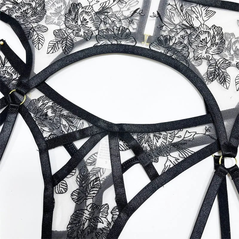 Black women's lace mesh floral print three-piece set with top, trousers, and waist ring on a hanger.