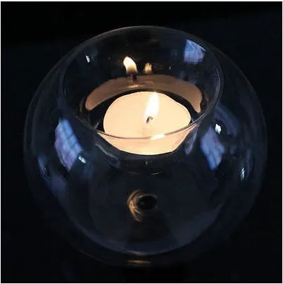 Handblown round hollow glass candle holder on a table, shown in frosted and clear finishes.