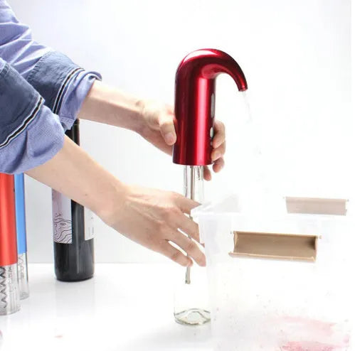 Portable electric wine pourer with black body, food-grade silicone catheter, and red light near a glass of red wine