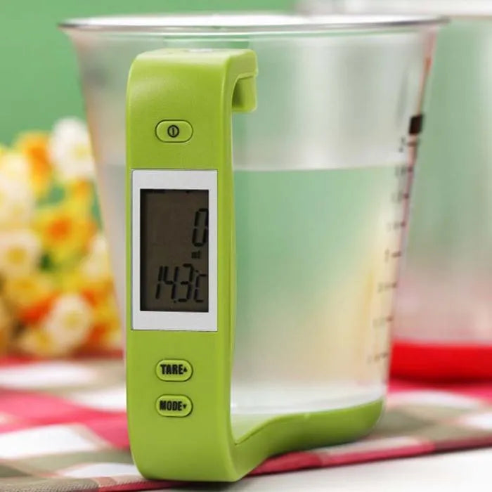 Green digital measuring cup scale with LCD display in handle on white background