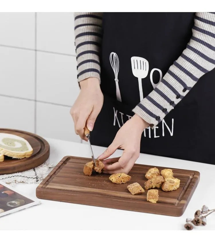 Black walnut wood cutting board with groove edge, rectangular shape, on kitchen counter