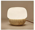 Cream-coloured retro style bedside lamp on a table.