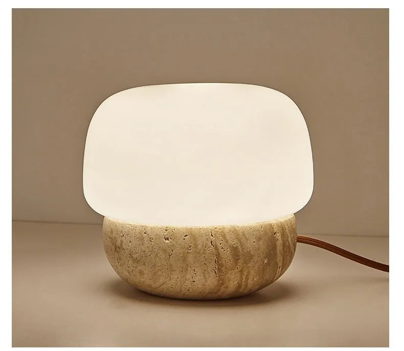 Cream-coloured retro style bedside lamp on a table.
