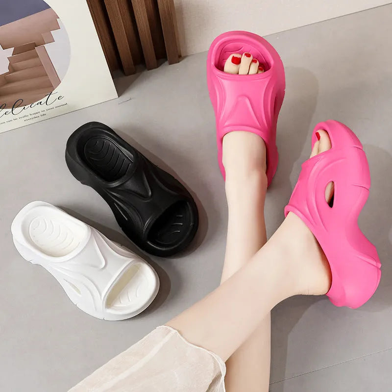 Women's thick-soled EVA slippers in rose red, white and black colours on a beach background.