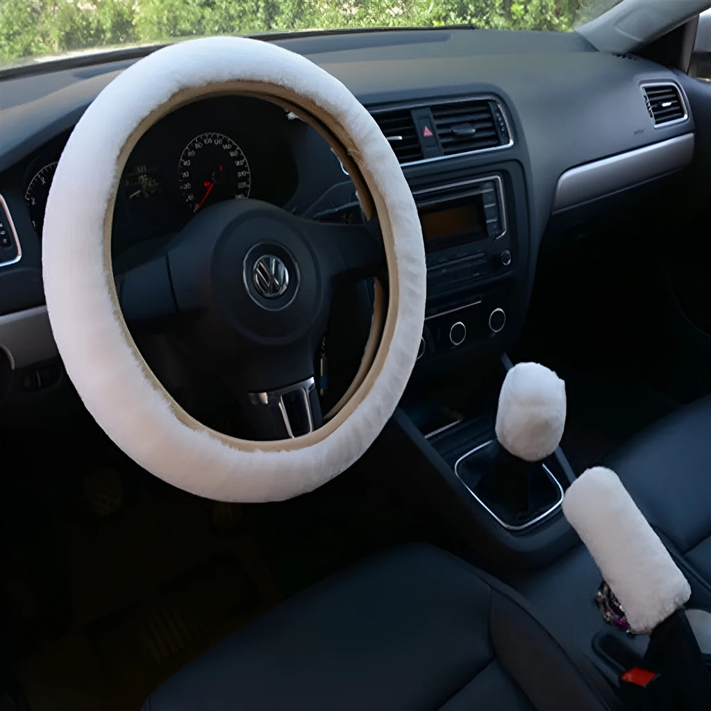 Winter plush car steering wheel cover set in black with matching gear shift and handbrake covers on a dark car interior