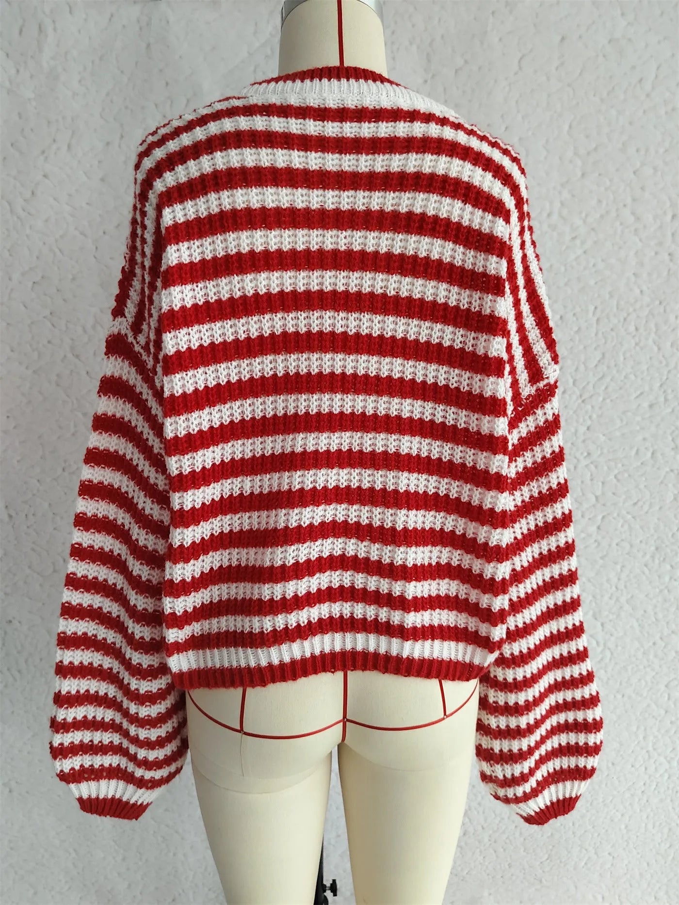 Woman wearing a loose-fitting black and white stripe pullover sweater with a round neck and long sleeves.