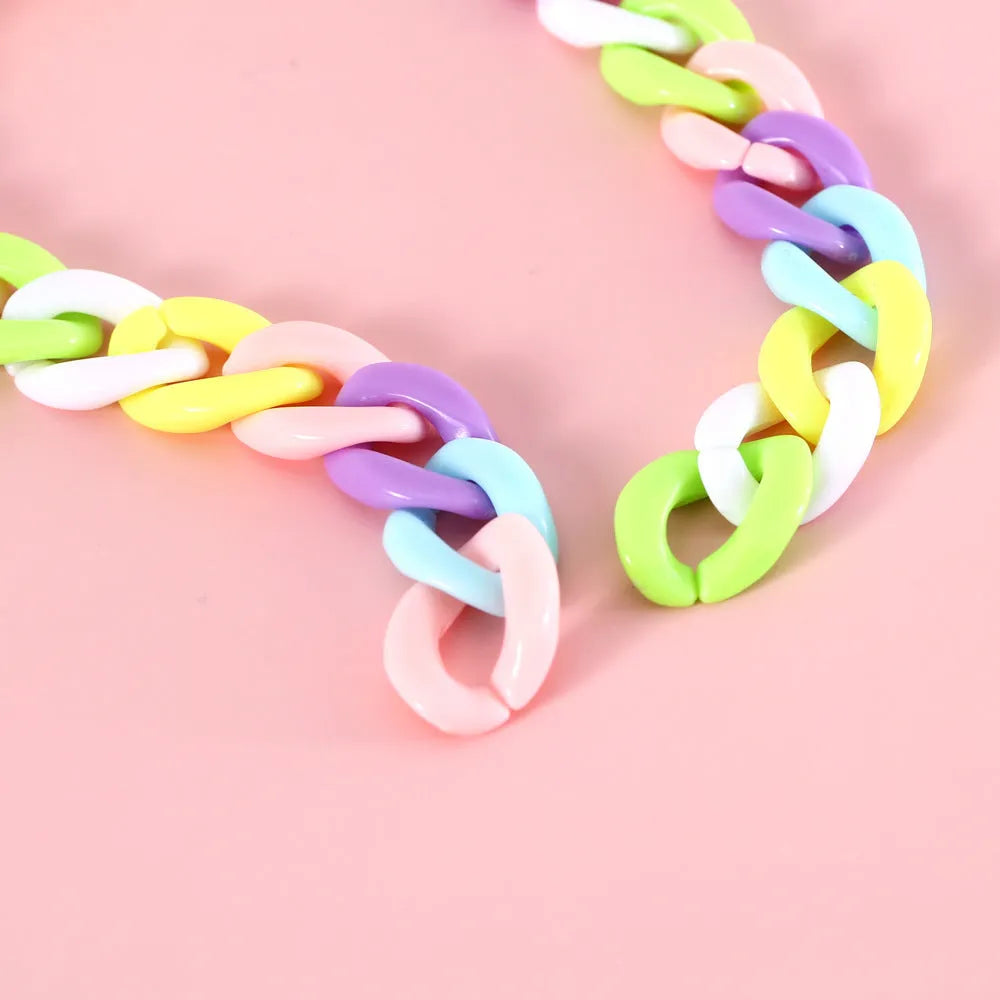 Adjustable plastic pet collar in macaron candy colours on a table, showing chain blue, pink, and mixed colour variants.