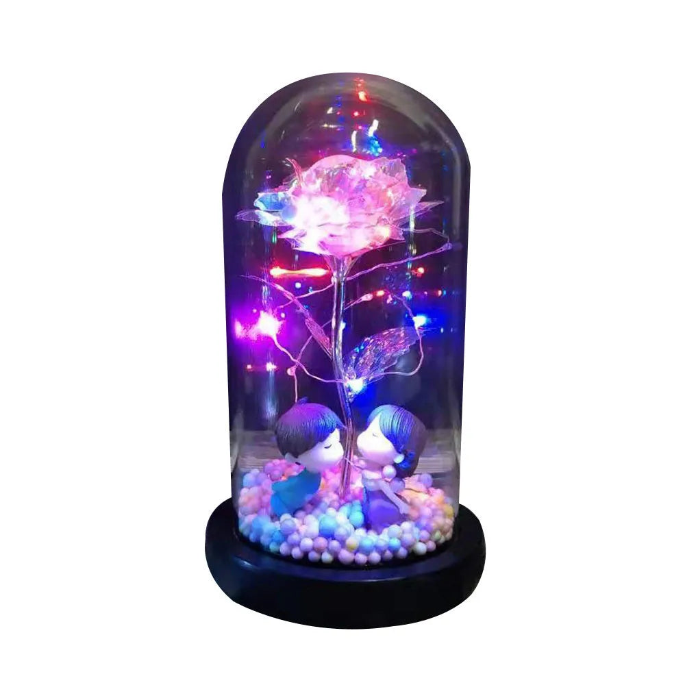 Gold artificial rose inside glass dome with LED lights on black base for home display