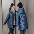A loose-fitting, thick hooded winter jacket for women in a champagne colour, showcasing long sleeves.
