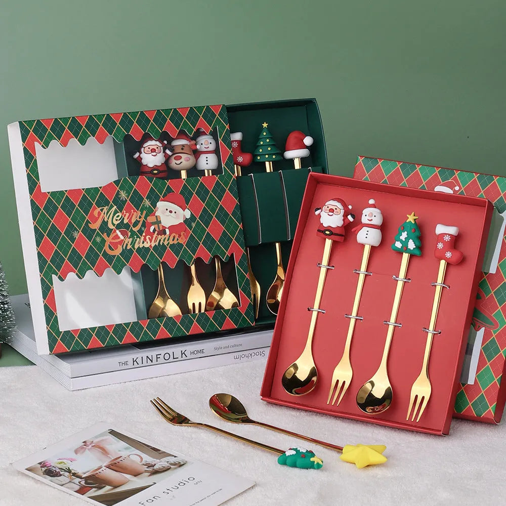 Four stainless steel Christmas spoons and forks with red handles showing Christmas tree and snowman designs on a white background