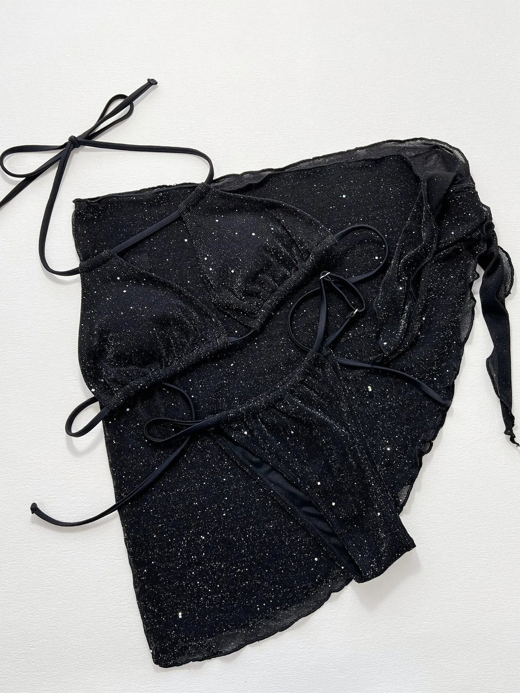 Black three-piece bikini swimsuit set with top and shorts on neutral background