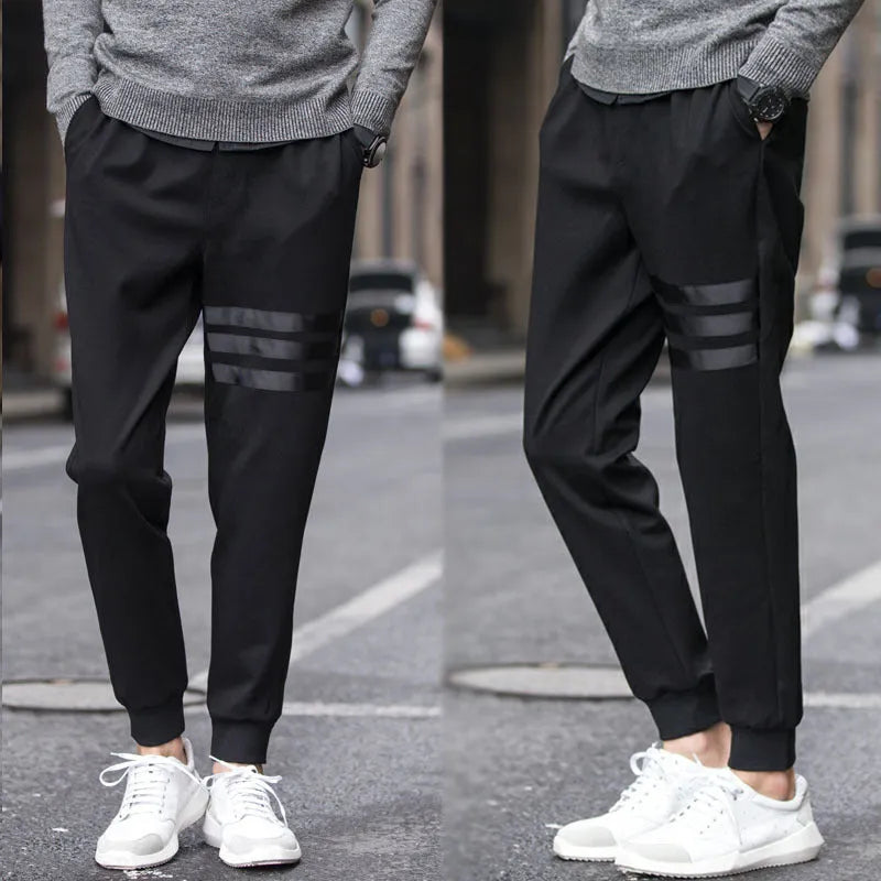 Men's casual slim sweatpants in black with elastic waistband and drawstring, side pockets, tapered leg, polyester fibre fabric