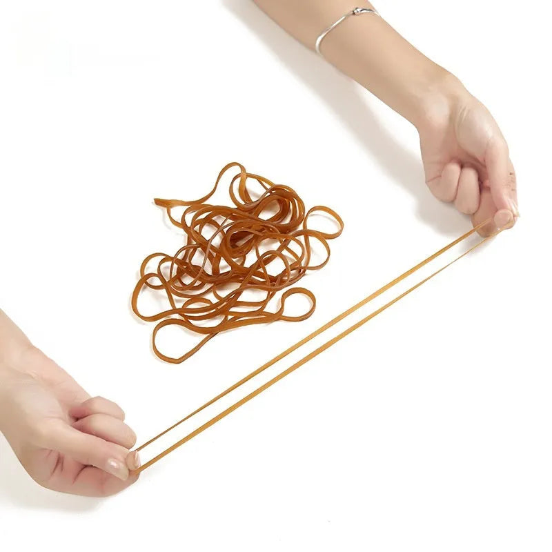 Circular natural rubber rings in natural colour on a surface in a 500g bulk bag