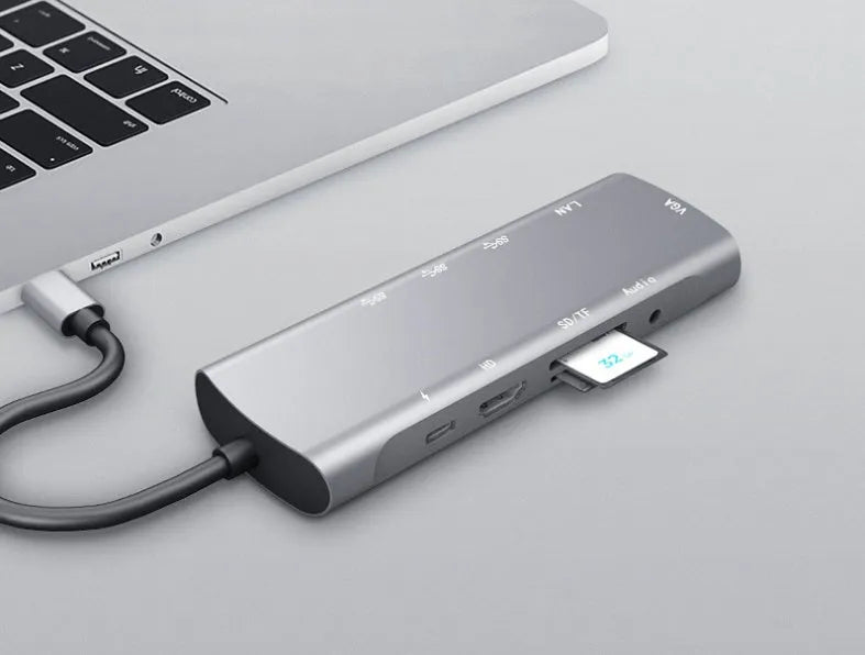 Grey aluminium USB-C docking station with HDMI, VGA, USB 3.0, and PD charging ports.