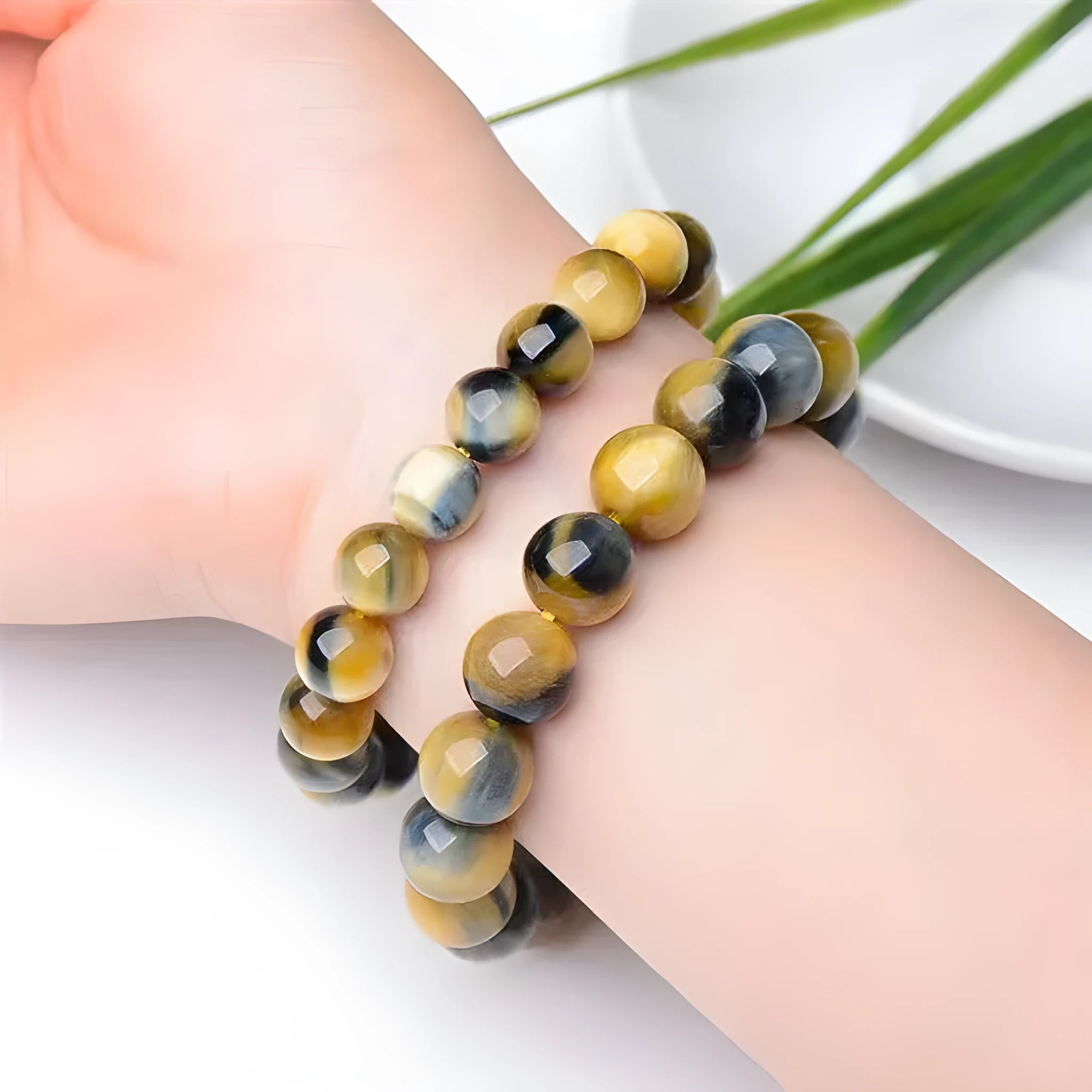 A fantasy tigereye agate bracelet with round geometric beads on a wrist.