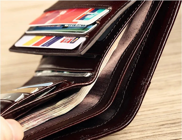 Men's black leather wallet open to show internal compartments for banknotes, cards, coins, and a concealed dark space.