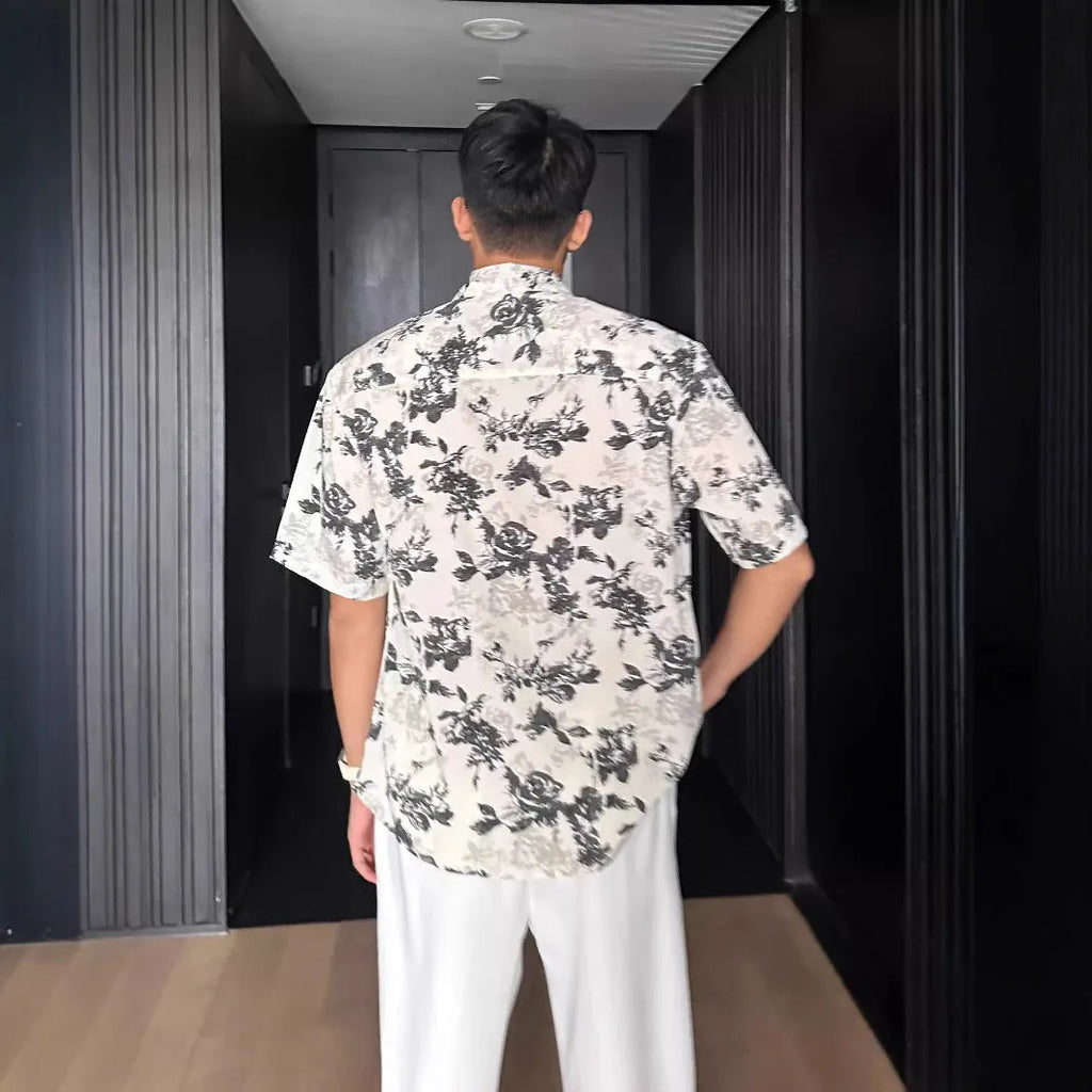 Loose fit black floral print short sleeve casual shirt on a hanger