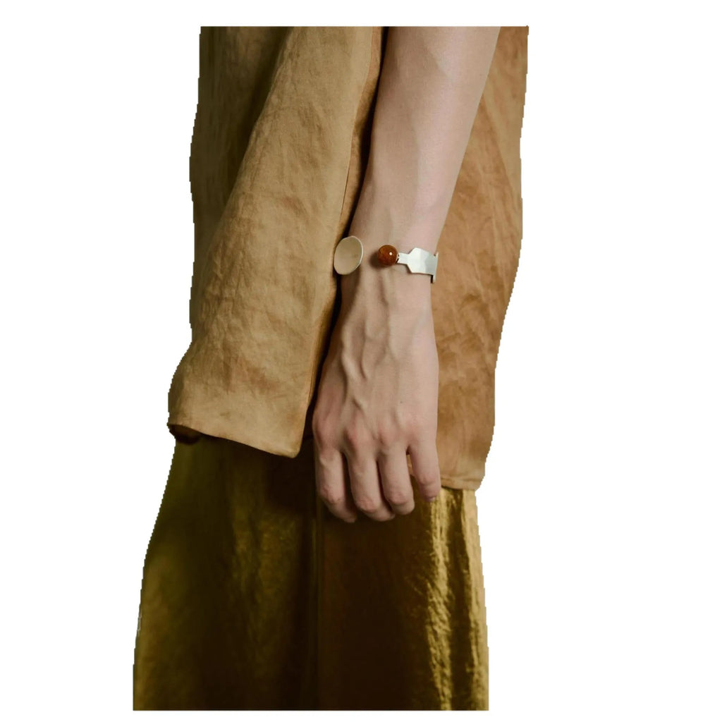 Electroplated alloy diamond-shaped stewed pork motif ring and bracelet set on a background.