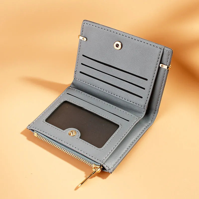 Open view of a short black PU leather ladies wallet showing multiple card slots, a zipper compartment, and a change pocket.