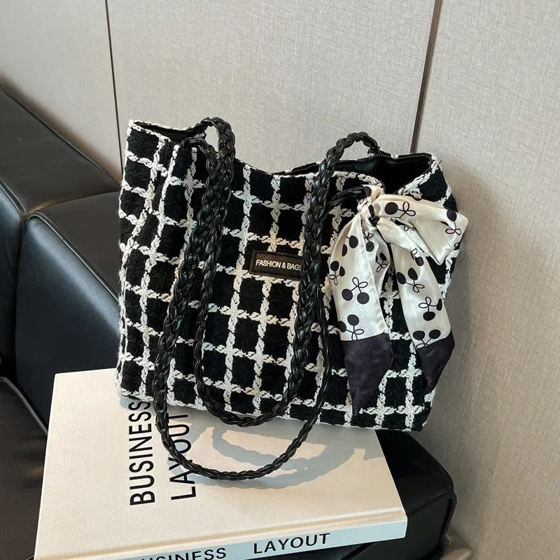 Black woven wool shoulder bag with horizontal square shape showing internal organiser compartments