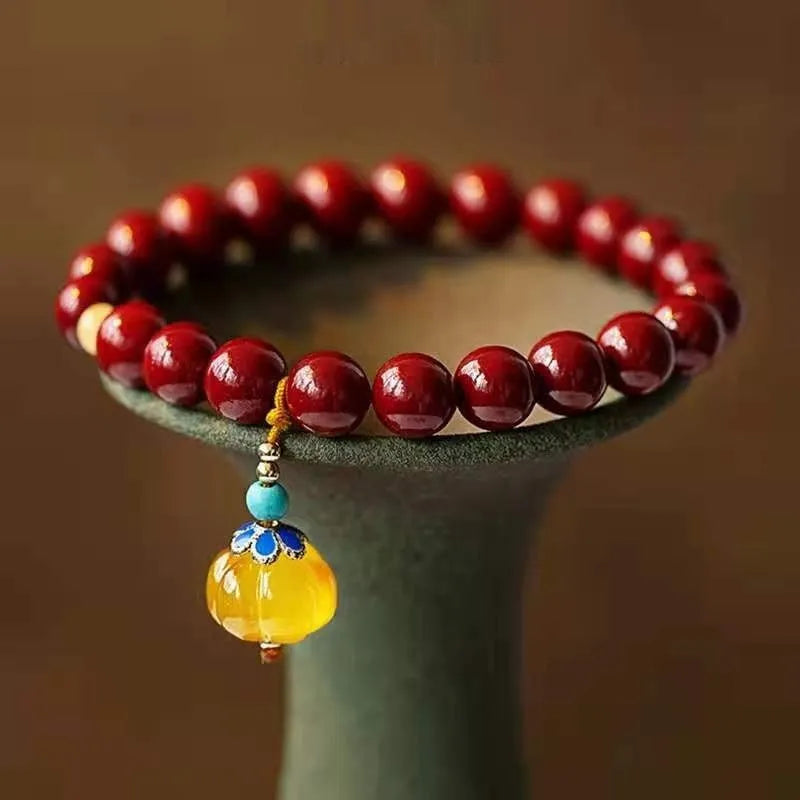 Handmade wave-shaped bracelet featuring cinnabar and copper beads on a wrist.