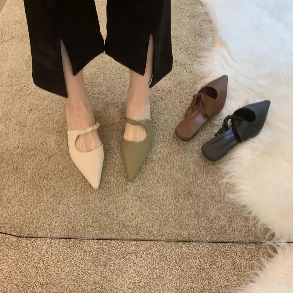 Women's soft leather semi-toe box slippers in black with rubber sole, side view.