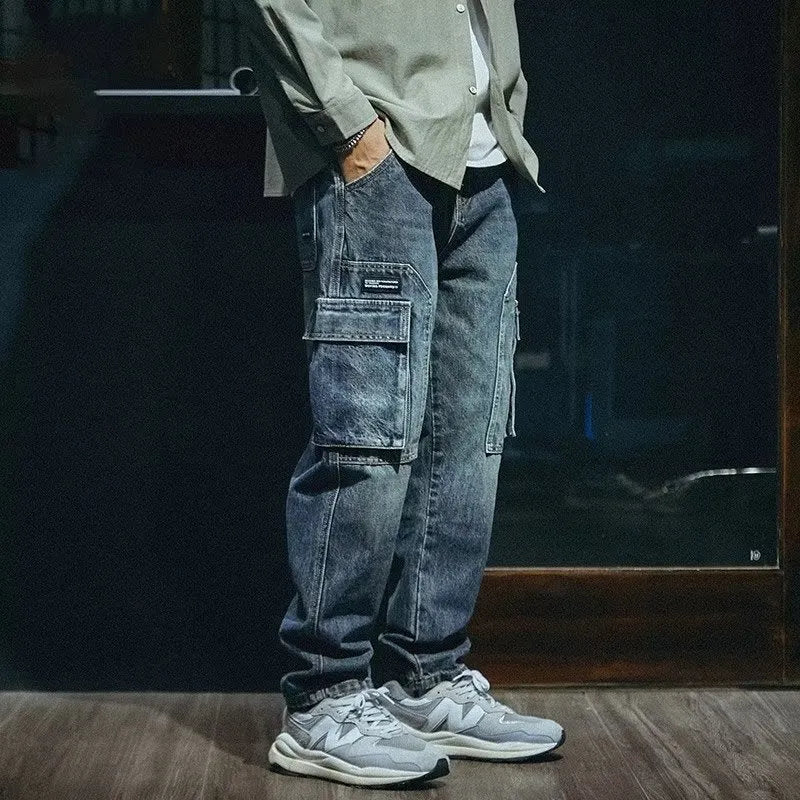 Man wearing blue loose straight-leg denim jeans with a zip fly, casual style.