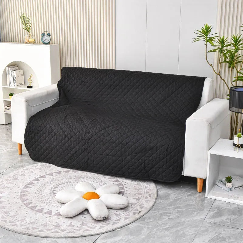 Reversible dog blanket on sofa showing two colour sides, protecting furniture from pets