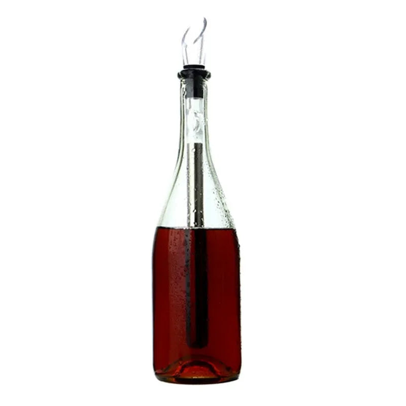 Silver stainless steel wine bottle cooler stick with built-in aerator and drip-free pouring nozzle on a table