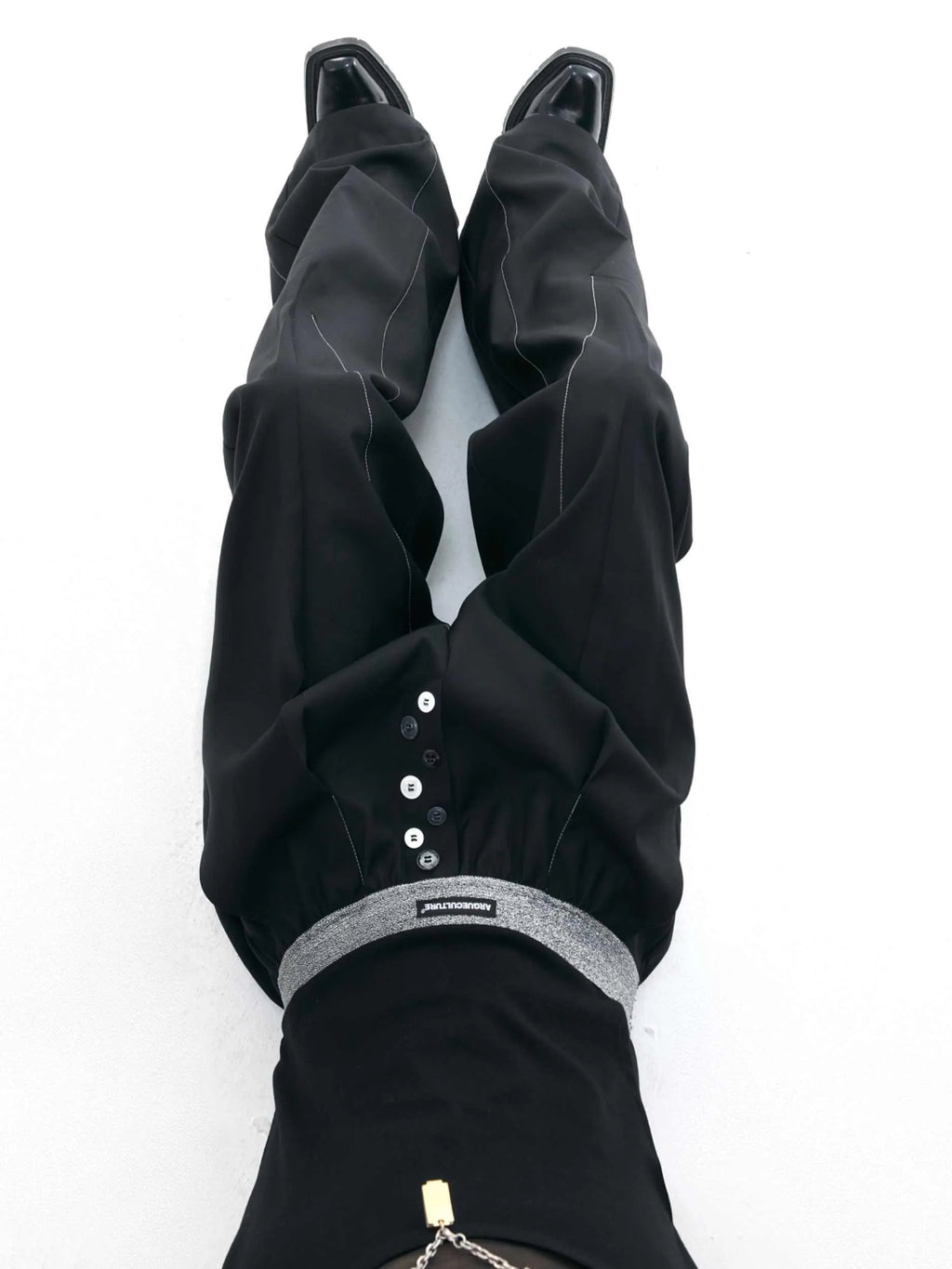 Drooping straight-leg high-waisted casual trousers with button detail in black and grey.
