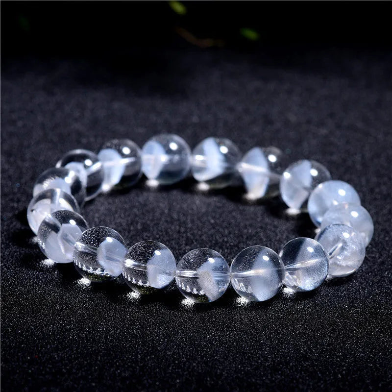 Women's natural white ghost pyramid crystal bracelet showing textured surfaces and ruyi charm detail