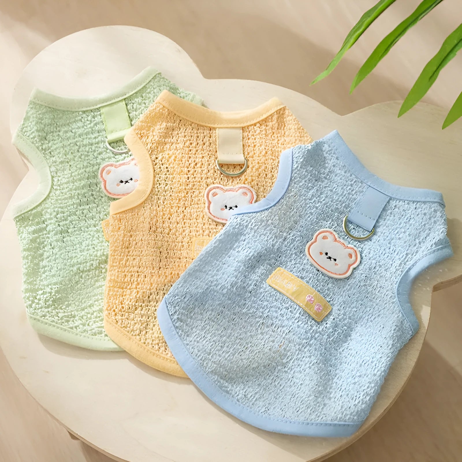 Green knitted cat clothing with a hollowed-out bear patch cartoon design.